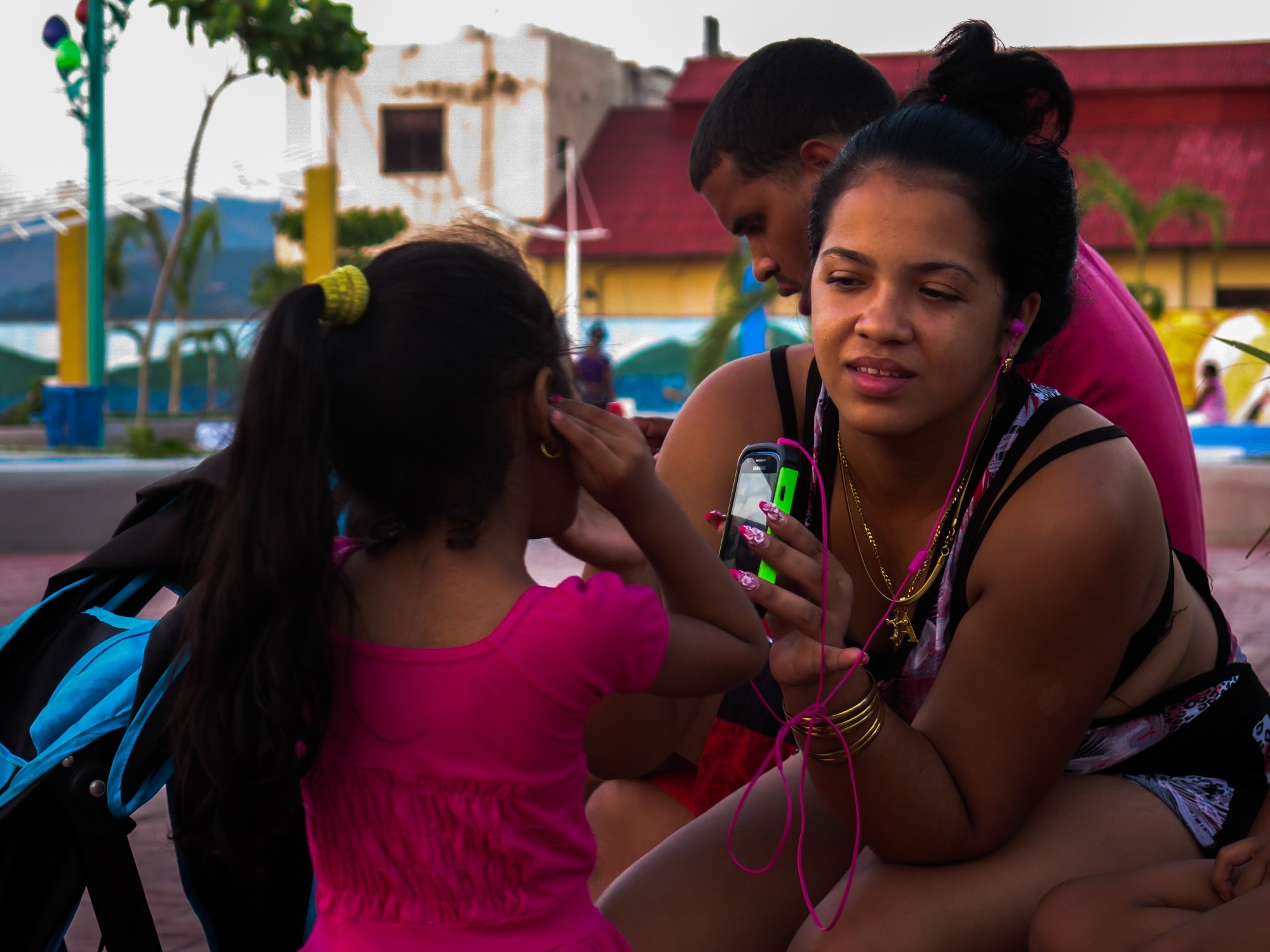 Madre e hija usan un teléfono móvil en Santiago de Cuba. Foto: Taylor Torres.
