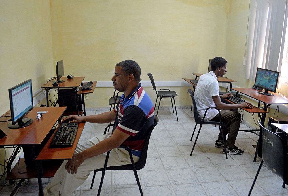 Dos personas utilizan computadoras en sala de un Joven Club.