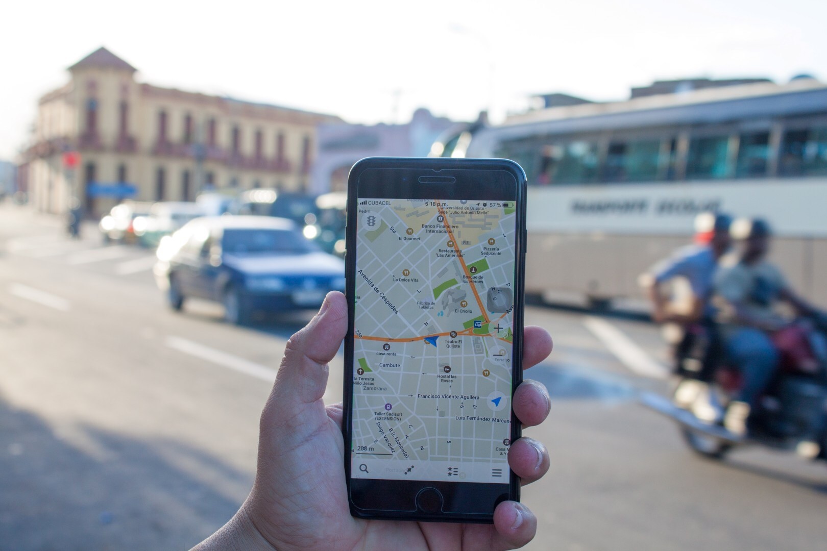 Un teléfono movil muestra en su pantalla un mapa en una calle de Santiago de Cuba. 