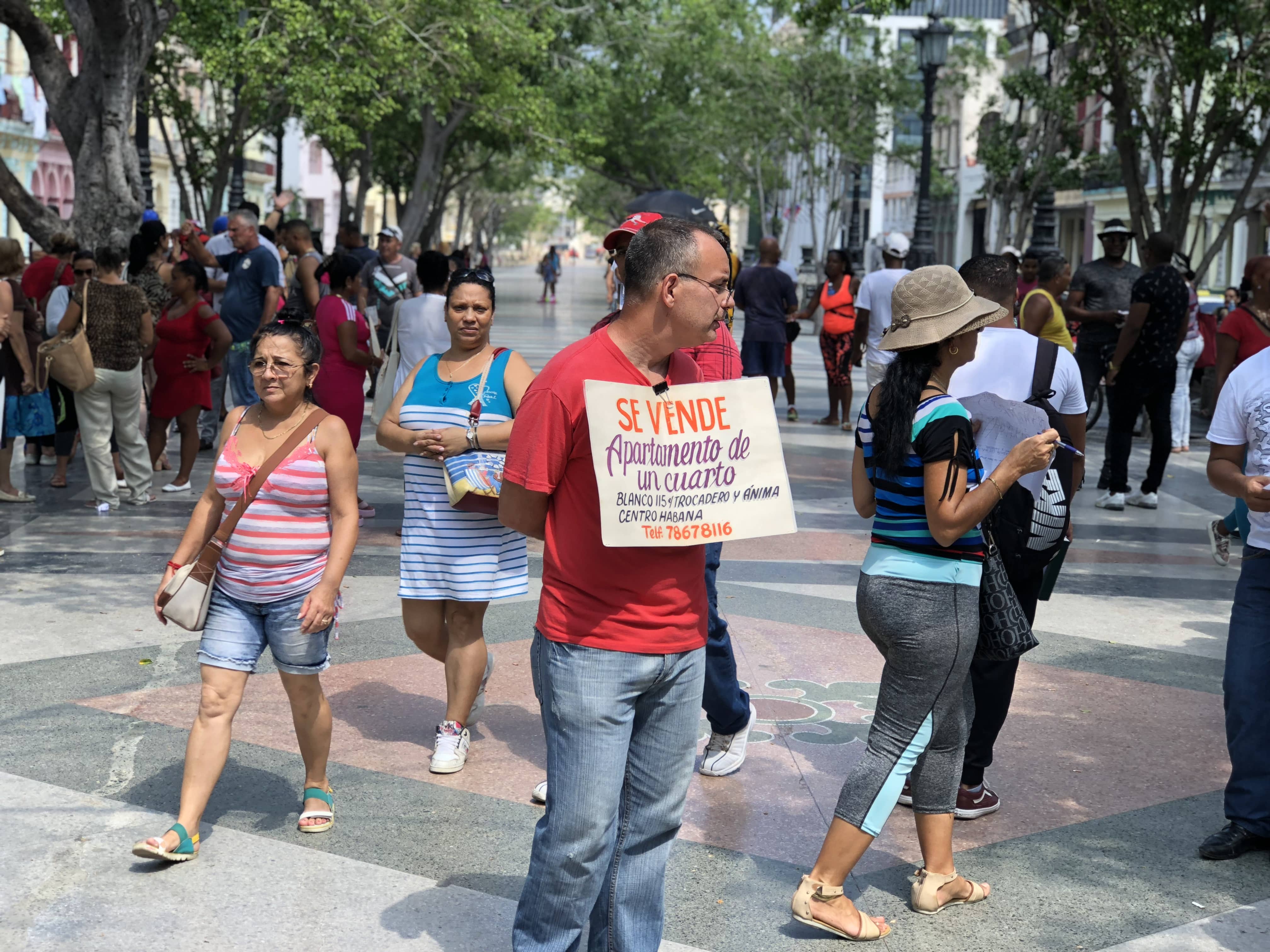 Hombre sosteniendo un anuncio clasificado en La Habana.