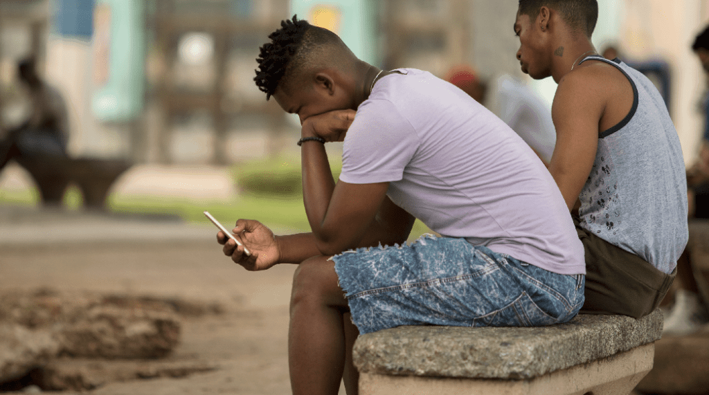 Joven cubano revisa su teléfono móvil