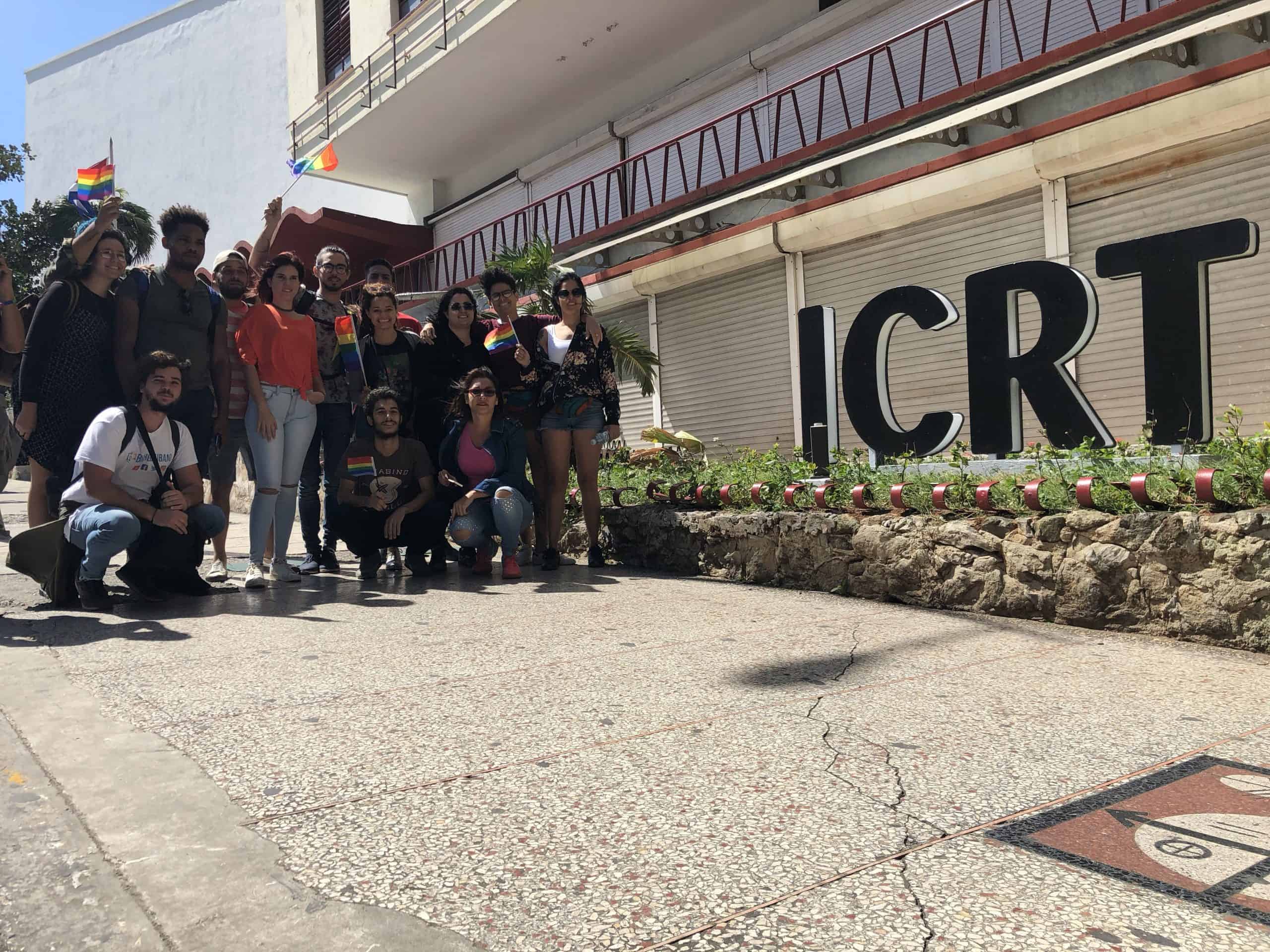 Activistas de la comunidad LGBT frente al letrero del ICRT